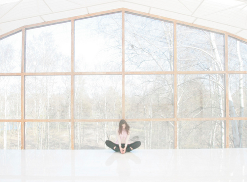 girl meditating in front of glass house