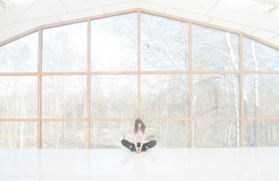 girl meditating in front of glass house