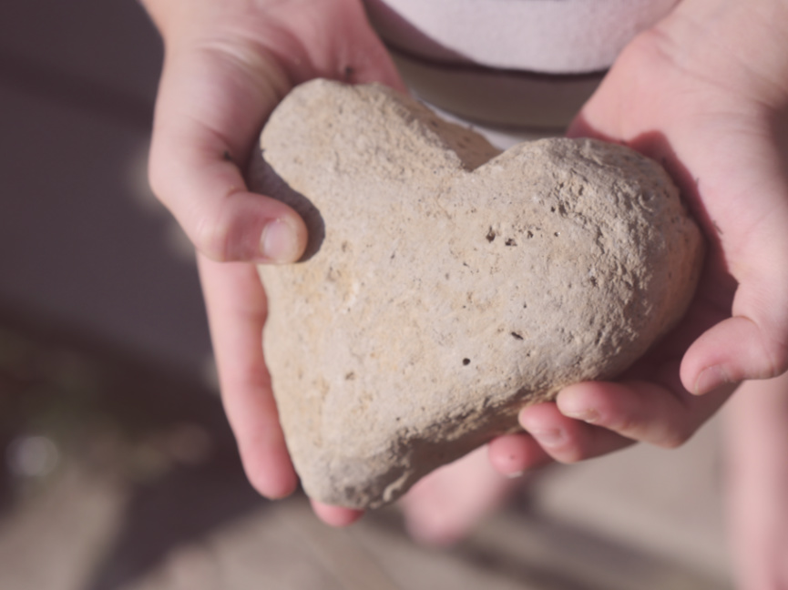 kid holding heart shaped rock